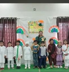 Children in festive dress on a decorated stage during a school celebration