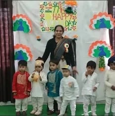 A Wonder Bees teacher on stage with young children during a school celebration