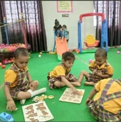 Young children seated on the floor of the activity room working on wooden puzzle boards