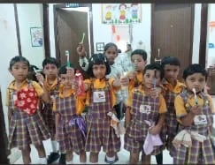 A group of children in Wonder Bees uniform standing together with a teacher inside the classroom